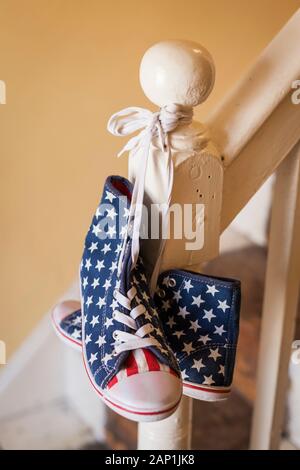 Une paire de stars and stripes chaussures haut haut accroché sur une rampe Banque D'Images