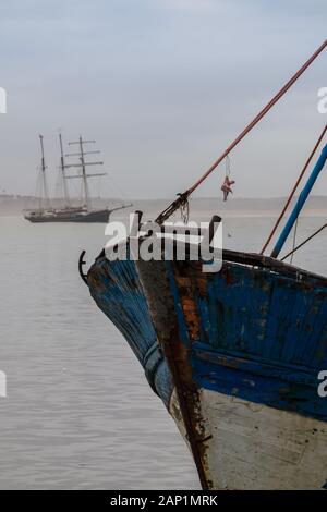 En bois peint bleu et blanc dans un vieux bateau de pêche port historique. De l'eau gris de l'océan Atlantique, ciel nuageux. Un autre bateau en arrière-plan. Es Banque D'Images