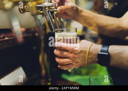 Barman verse la bière dans le verre de touchez Banque D'Images