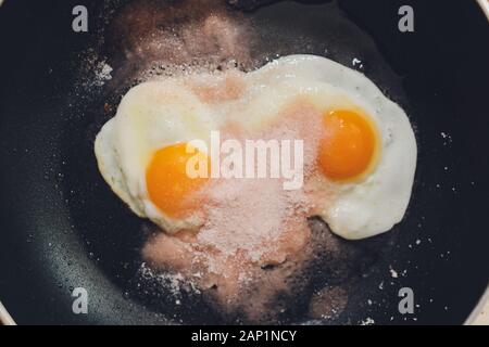 Photographie d'appétissants œufs brouillés d'un oeuf de poule dans une casserole avec l'huile de tournesol d'ébullition Banque D'Images