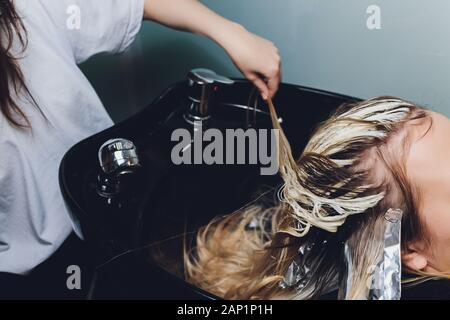 Libre de coiffure mains séparant les brins de cheveux de belle jeune femme avec une feuille d'aluminium avant de changer la couleur des cheveux Banque D'Images