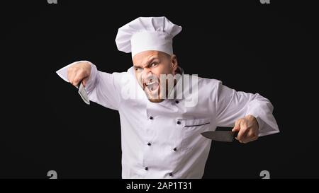 Couteaux Chef crazy man posing in Studio menaçant, Panorama Banque D'Images