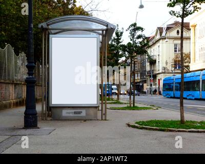 Structure en verre abri bus le long du trottoir de la rue. scène d'été avec le tram bleu. blanc panneaux publicitaires. copier et annonce l'espace. concept de commercialisation. Banque D'Images