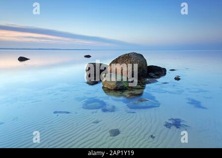 Rochers dans la mer Baltique à marée basse / ebb au crépuscule en hiver, Mecklembourg-Poméranie-Occidentale, Allemagne Banque D'Images