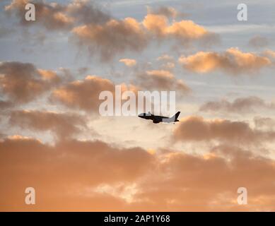 Un avion commercial prend son décollage à l'aéroport international d'Orlando au coucher du soleil. Banque D'Images