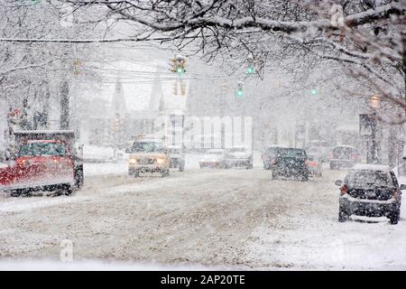 La circulation sur une rue de banlieue couvertes de neige pendant une tempête hivernale Banque D'Images