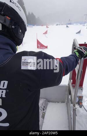 Coupe du monde de snowboard 2020 Rogla, en Slovénie. Un concurrent au début-gate se concentre dans la ligne gaint sloop de slalom. Banque D'Images