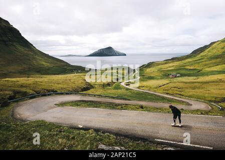 Jeunes patineurs équitation une planche à roulettes à travers le paysage magnifique des îles Féroé Banque D'Images