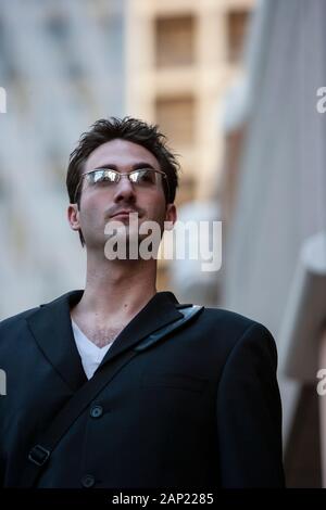 Portrait d'un homme millénaire confiant portant des lunettes de soleil en plein air Banque D'Images
