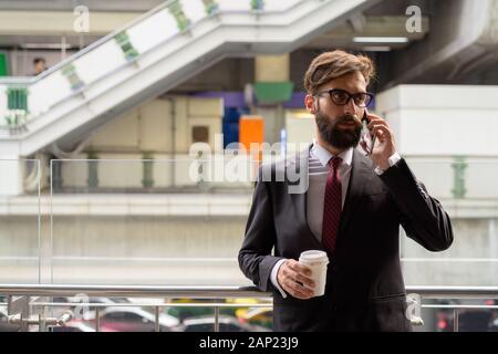 Beau jeune homme persan barbu détendre autour de la ville Banque D'Images