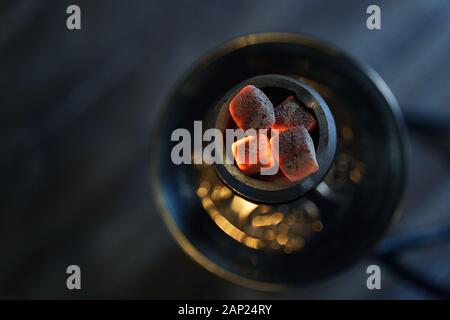 Shaha hokah bol avec des coals chauds rouges et du tabac artisanal. Le hookah moderne avec charbon de noix de coco pour se détendre et fumer. Magnifique bokeh et confortable salon sombre Banque D'Images