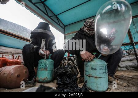 Bureij, Territoires palestiniens. 20 Jan, 2020. Palestiniens masqués remplir des préservatifs avec un gaz réfrigérant avant d'être attachés à des dispositifs incendiaires et les matériaux inflammables à les libérer pour être propulsé par le vent dans le territoire israélien, près de la frontière Israel-Gaza. Credit : Mohammed Talatene/dpa/Alamy Live News Banque D'Images