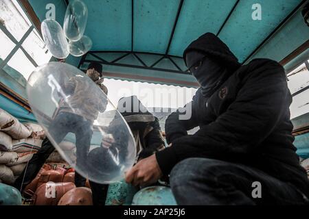 Bureij, Territoires palestiniens. 20 Jan, 2020. Un Palestinien masqué se remplit de préservatifs avec un gaz réfrigérant avant d'être attachés à des dispositifs incendiaires et les matériaux inflammables à les libérer pour être propulsé par le vent dans le territoire israélien, près de la frontière Israel-Gaza. Credit : Mohammed Talatene/dpa/Alamy Live News Banque D'Images