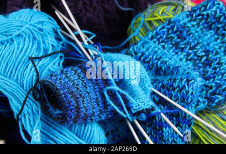 Matériel de couture : vue sur tricoté bleu chaussettes bébé dans panier avec balles de laine Banque D'Images