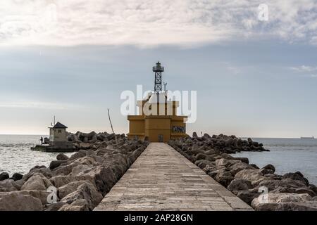 Beau vieux phare sur la côte de Venise Italie Europe. Le phare sur la plage de rochers et l'océan en arrière-plan Banque D'Images