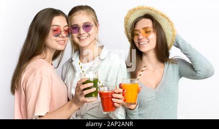 Cheerful young in sunglasses boire smoothie frais sain Banque D'Images