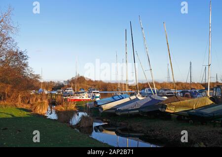 Un groupe de yachts hors de l'eau et couverts sur les Norfolk Broads par Malthouse Broad à Ranworth, Norfolk, Angleterre, Royaume-Uni, Europe. Banque D'Images