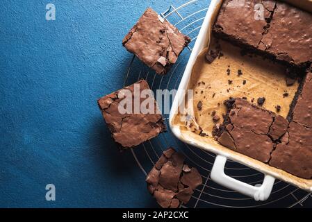 Meilleur dessert brownies dans un moule blanc et sur un bac de refroidissement, sur phantom tableau bleu. Voir ci-dessus des brownies. Délicieux gâteau au chocolat. Banque D'Images