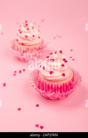 Deux saint valentin love cupcakes décoration crème et coeurs sur fond rose avec copie espace pour le texte Banque D'Images