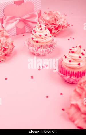 Amour saint valentin décoration cupcake à la crème et rose fleurs et coeurs sur fond rose cadeaux avec copie espace pour le texte Banque D'Images