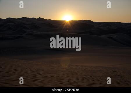 Vue sur le coucher du soleil du désert d'atacama depuis une dune de sable près de l'oasis Huacachina, près D'Ica, Pérou Banque D'Images