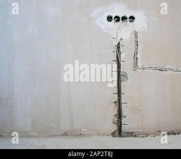 Trou dans le mur sous le socket Banque D'Images