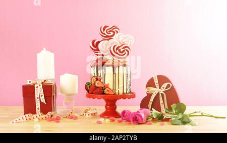 St-valentin sur-tendance candyland fantasy nouveauté égouttoir gâteau décoré avec des bonbons, des sucettes en forme de coeur et de fraises fraîches, avec un lens flare Banque D'Images