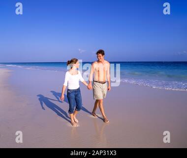 Jeune couple walking on beach, South Shore, Warwick Parish, Bermudes Banque D'Images