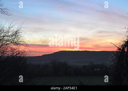 Zone de haute pression typique de climat calme anticyclone en hiver. Fackenden Vers Le Bas en janvier soir alors que le soleil se couche derrière la crête de craie des North Downs Banque D'Images