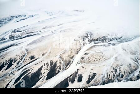 Vue de dessus de l'eau recouvert de neige tournant à droite et collectivement de se jeter dans la brume en haut des terres montagneuses Banque D'Images