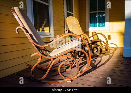 Fauteuil à bascule en bois sur porche au coucher du soleil personne n Banque D'Images