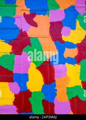 Formes colorées, peintes et géométriques de puzzle sur mur urbain de briques Banque D'Images