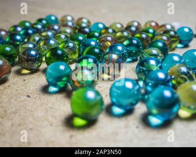 Boules de verre de couleur éparpillées sur la surface en bois Banque D'Images