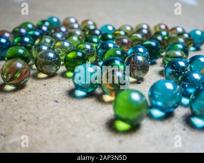 Boules de verre de couleur éparpillées sur la surface en bois Banque D'Images