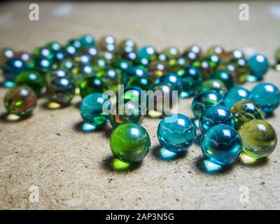 Boules de verre de couleur éparpillées sur la surface en bois Banque D'Images