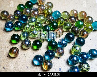 Boules de verre de couleur éparpillées sur la surface en bois Banque D'Images