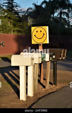 Groupe de boîtes aux lettres pour la livraison quotidienne avec une bonne face sur eux dans la rue dans la zone rurale du centre de CA Banque D'Images