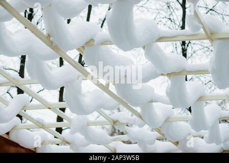 Gros plan du garde-corps en bois, côté patio clôture pôle, post couvertes, empilé, tas de neige après une tempête de neige lourde, tempête en chambre, la maison, la lumière du soleil Banque D'Images