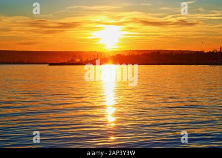 Coucher de soleil sur le front de mer de Varna, le Port de Varna au loin, côte de la mer Noire Bulgarie Banque D'Images