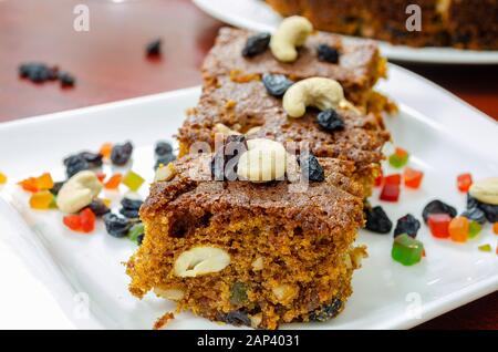 Très gros plan de tranches de gâteau aux prunes avec des fruits secs saupoudrés sur eux. Banque D'Images