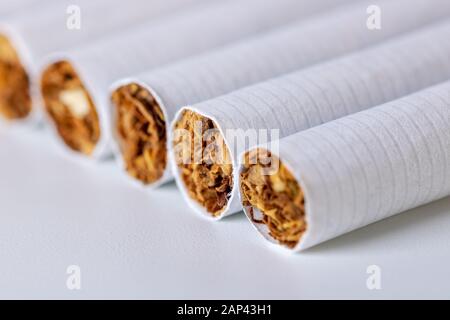 Gros plan d'une pile de cigarettes sur fond blanc Banque D'Images