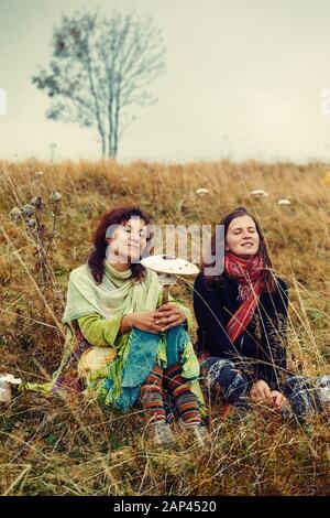 Deux filles sur une colline avec des champignons à la main. Banque D'Images