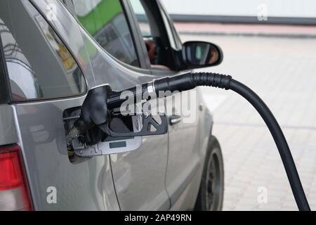 Location de remplir avec l'essence à une station-service. Close up du pompage du carburant de l'essence en gris voiture à une station-service. Banque D'Images