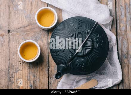 Recette traditionnelle japonaise de tisanes préparée dans de la théière en fonte avec des herbes biologiques sèches d'en haut. Vue de dessus de la boisson chaude traditionnelle asiatique sur W Banque D'Images