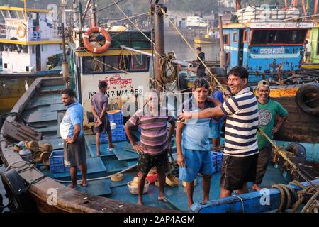 Pêcheurs sur leurs bateaux ancrés à Sassoon Docks, un port de pêche dans la région de Colaba, Mumbai, Inde Banque D'Images
