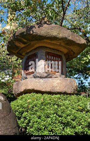 Vue sur la lanterne en pierre japonaise Nazura-doro faite de pierres rugueuses et non polies dans le temple Isshin-ji d'Osaka. Japon Banque D'Images