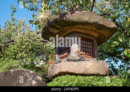 Vue sur la lanterne en pierre japonaise Nazura-doro faite de pierres rugueuses et non polies dans le temple Isshin-ji d'Osaka. Japon Banque D'Images