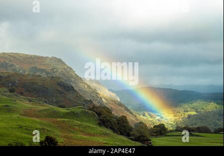 Un arc-en-ciel s'élève au-dessus des collines de Coniston, du côté de l'eau de Coniston, dans le parc national du district du lac Cumbria. Inhabituel de le voir si près du bord Banque D'Images