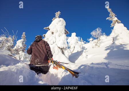 Le skieur monte en montée pour la neige fraîche au freeride le jour ensoleillé de l'hiver Banque D'Images