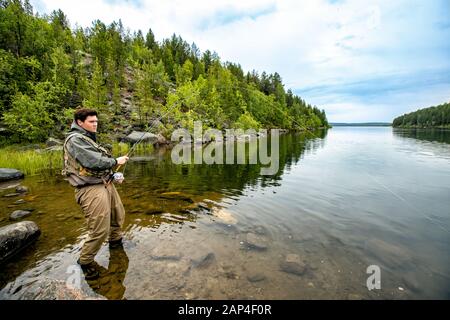 Pêcheur utilisant la pêche à la mouche de la tige dans la rivière matin debout dans l'eau Banque D'Images